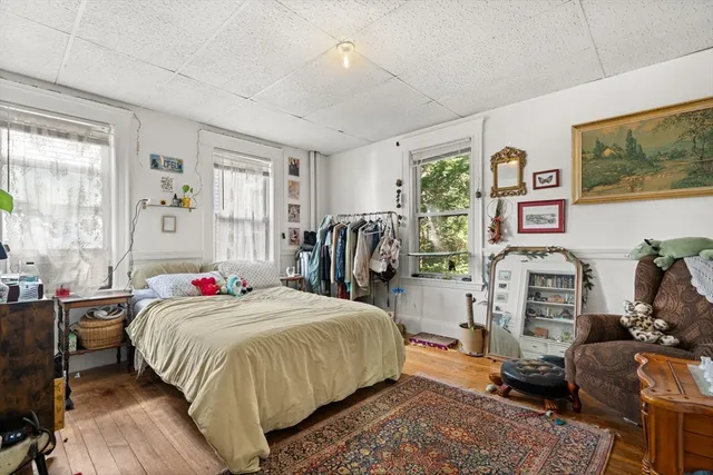 a bedroom with a bed and wooden floor