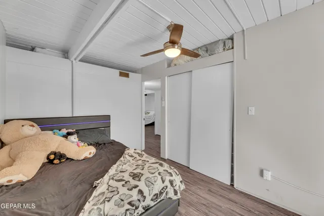 a bedroom with bed and wooden floor