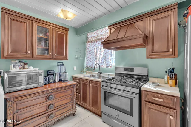 a kitchen with stainless steel appliances granite countertop a stove a sink dishwasher and cabinets with wooden floor