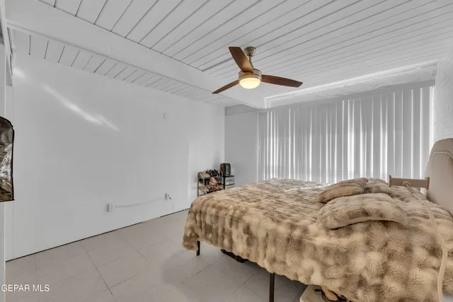 a bed sitting in a spacious bedroom next to a window