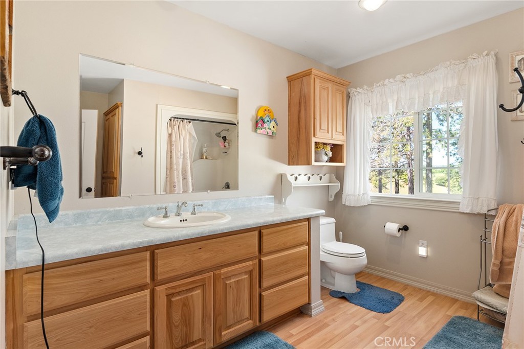 5735 Lunt Road Yankee Hill, CA 95965 - Photo 15 of 48 a bathroom with a granite countertop sink toilet a large mirror and a window