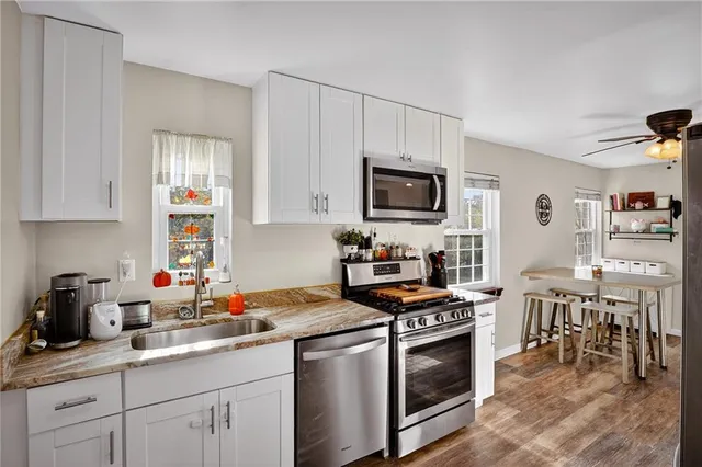 a kitchen with stainless steel appliances a stove sink microwave and cabinets