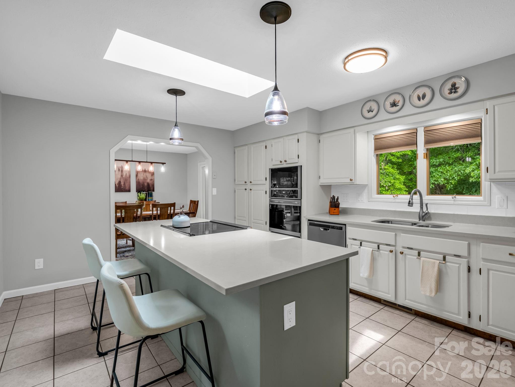 656 Cashiers Valley Road Brevard, NC 28712 - Photo 10 of 37 a kitchen with stainless steel appliances a table chairs and chandelier