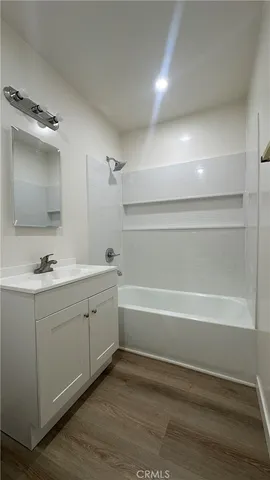 a bathroom with a tub sink double vanity and mirror