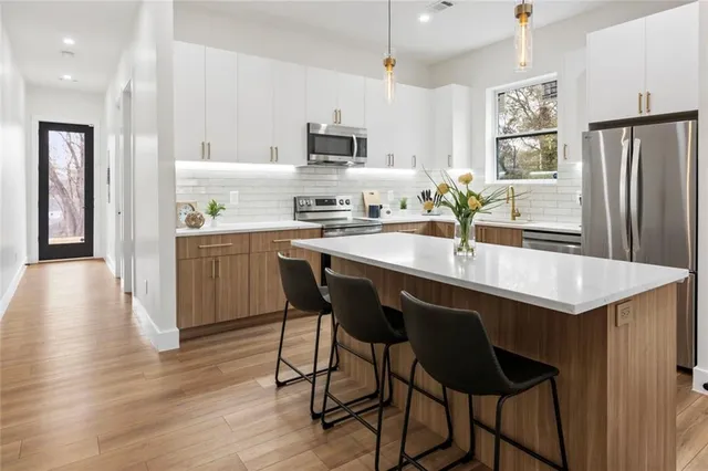a kitchen with stainless steel appliances a stove a sink and a refrigerator