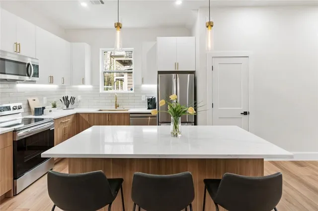 a kitchen with kitchen island a sink stove top oven and refrigerator