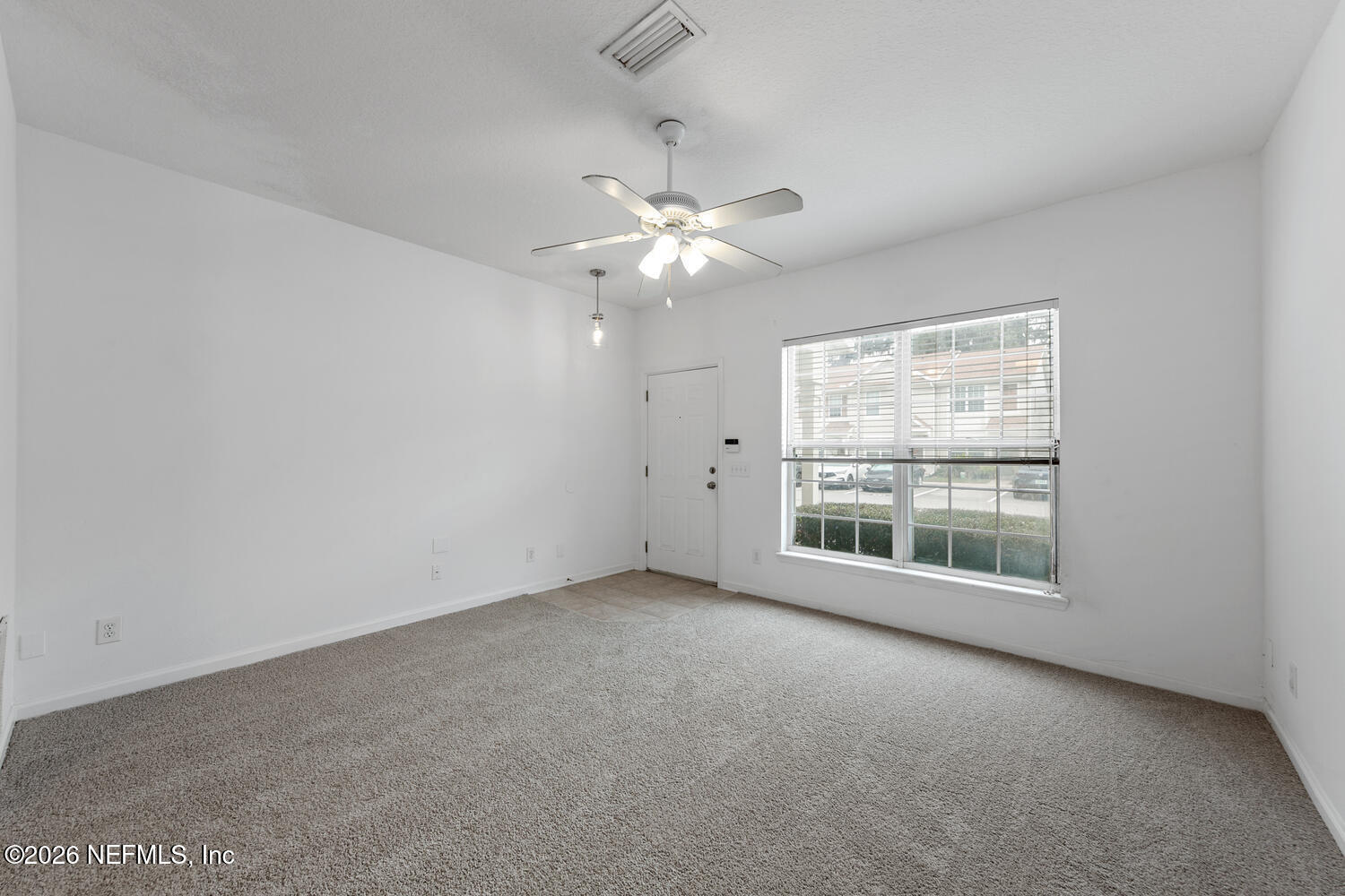3532 Twisted Tree Lane Jacksonville, FL 32216 - Photo 11 of 23 an empty room with chandelier fan and windows