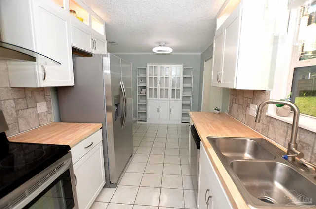 a kitchen that has a sink stainless steel appliances a counter space and a window