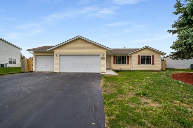 a view of a house with a yard and garage