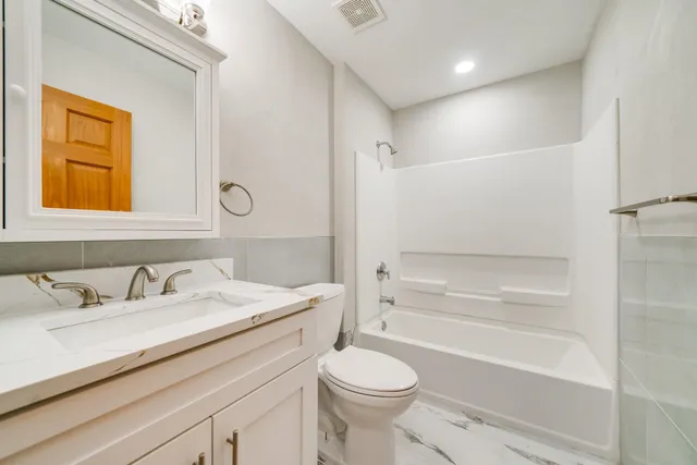 a bathroom with a granite countertop sink toilet and shower