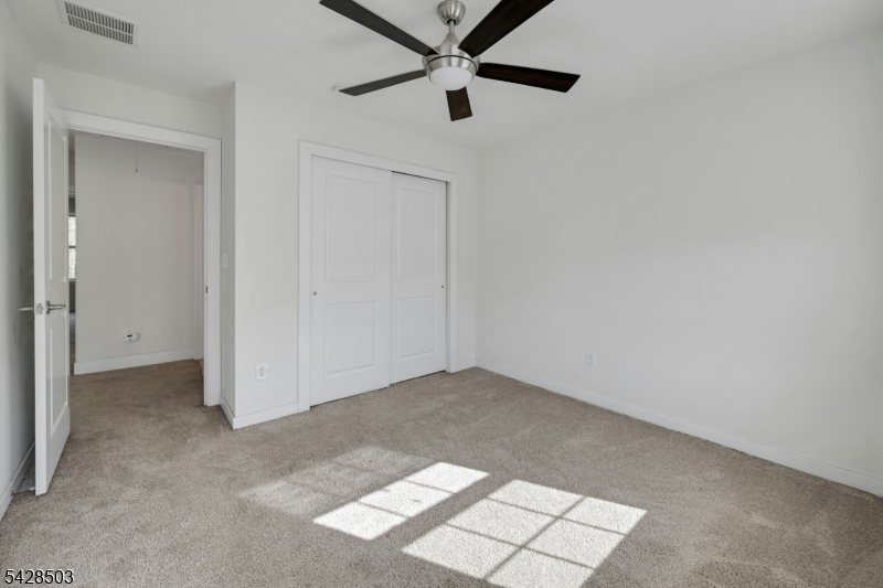 1808 Devon Lane Rockaway, NJ 07866 - Photo 22 of 35 an empty room with a ceiling fan and carpet