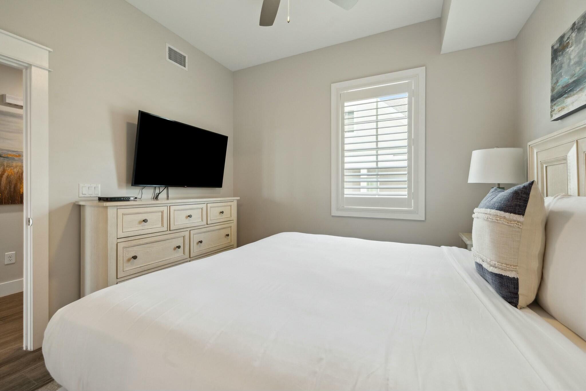 202 Henderson Resort Way, Unit 1204 Destin, FL 32541 - Photo 25 of 29 a bedroom with a bed and a flat screen tv