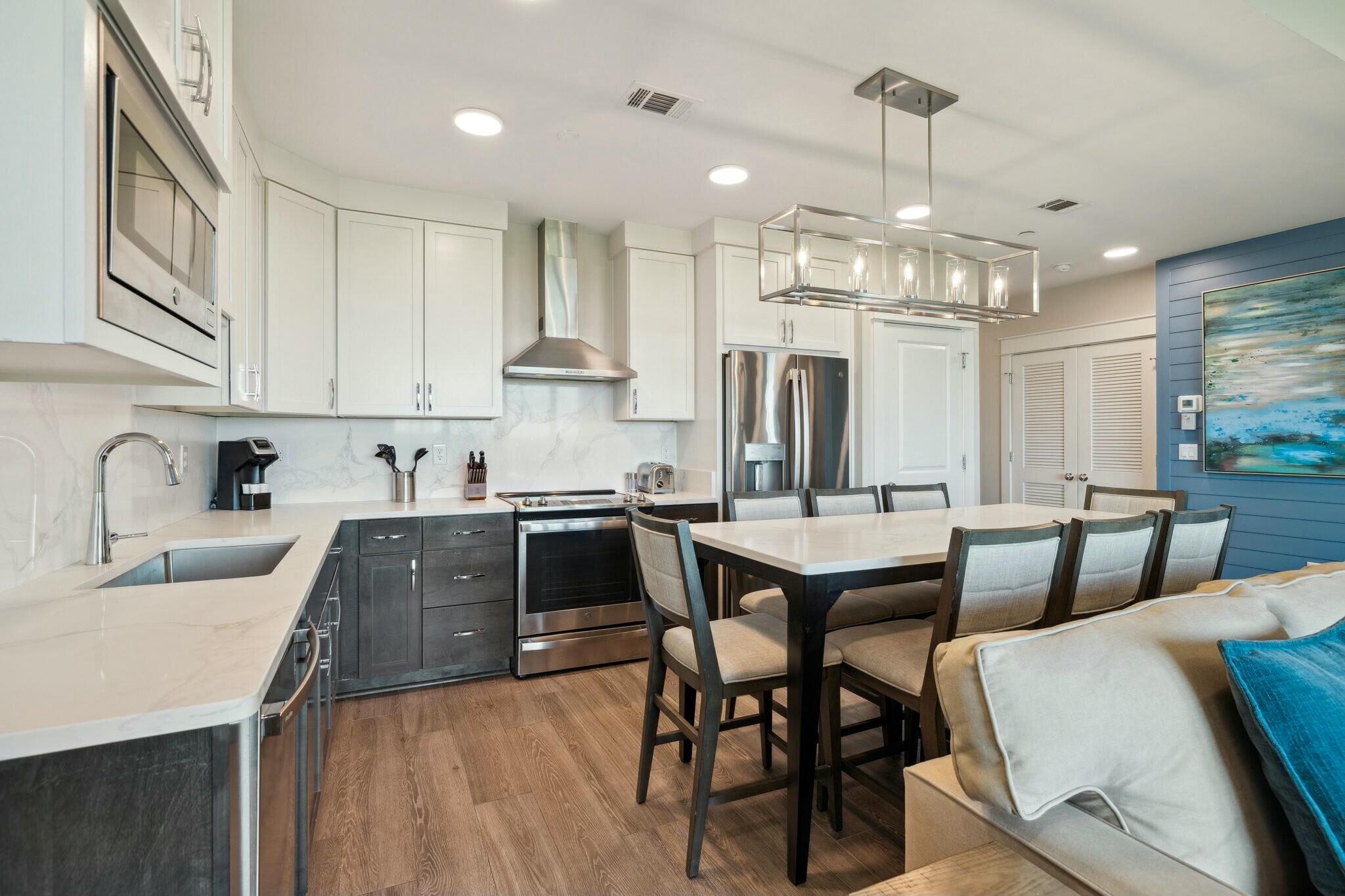 202 Henderson Resort Way, Unit 1204 Destin, FL 32541 - Photo 9 of 29 a kitchen with stainless steel appliances granite countertop a sink a stove a refrigerator cabinets and chairs