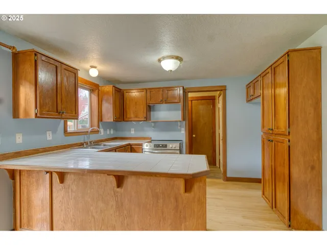 a kitchen with stainless steel appliances granite countertop a sink refrigerator and cabinets
