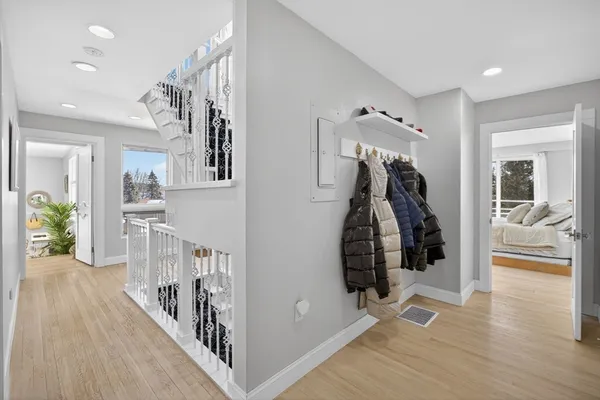 a view of a hallway with wooden floor and stairs