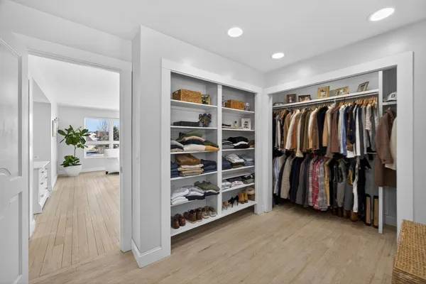 a view of walk in closet with clothes and shoes