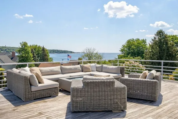 a roof deck with couches and wooden floor
