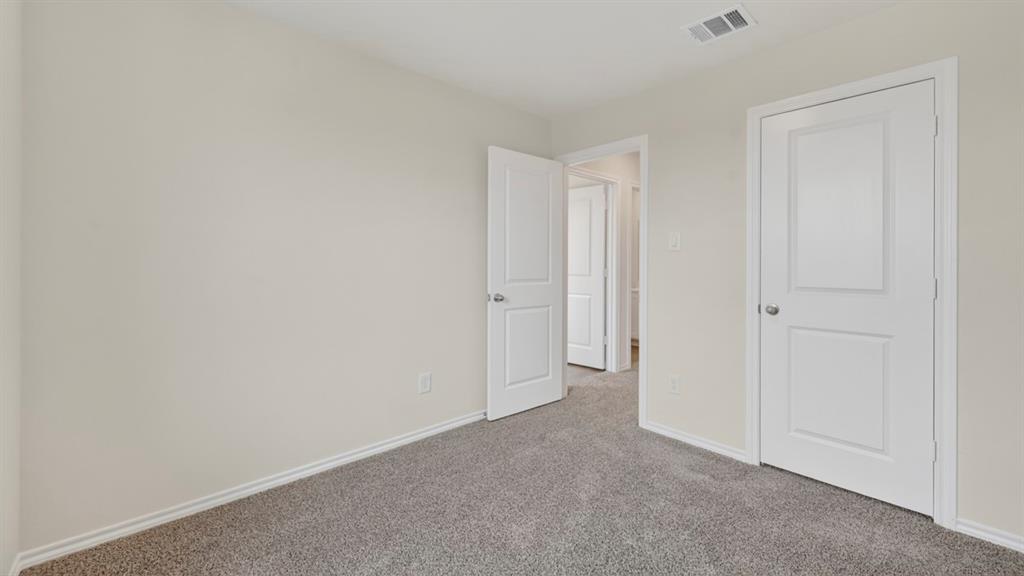 3534 Spring Time Street Forney, TX 75126 - Photo 22 of 24 Neutral-toned walls complement gray carpeting in this interior space