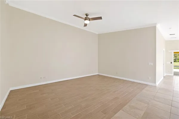 an empty room with a ceiling fan and wooden floor