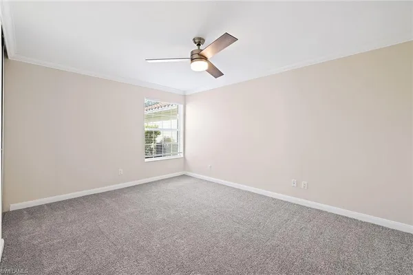 a view of empty room with window and ceiling fan