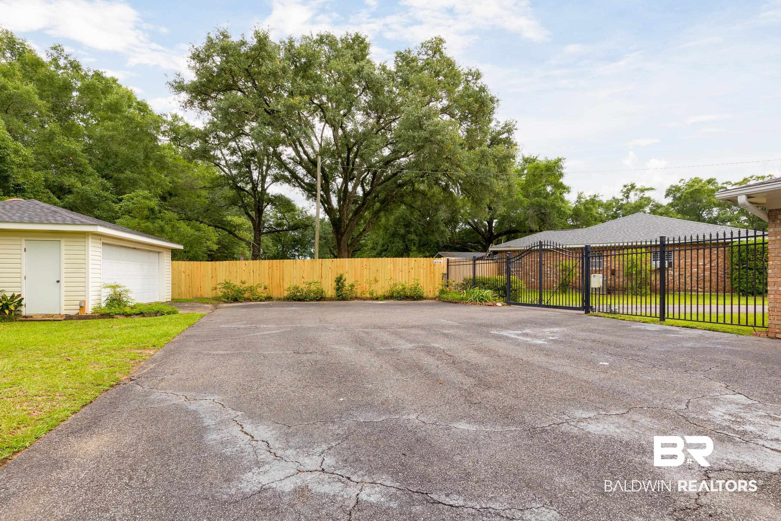 1367 Spring Valley Court Mobile, AL 36693 - Photo 17 of 29 Paved driveway with an attached two-car garage featuring vinyl siding and a shingled roof