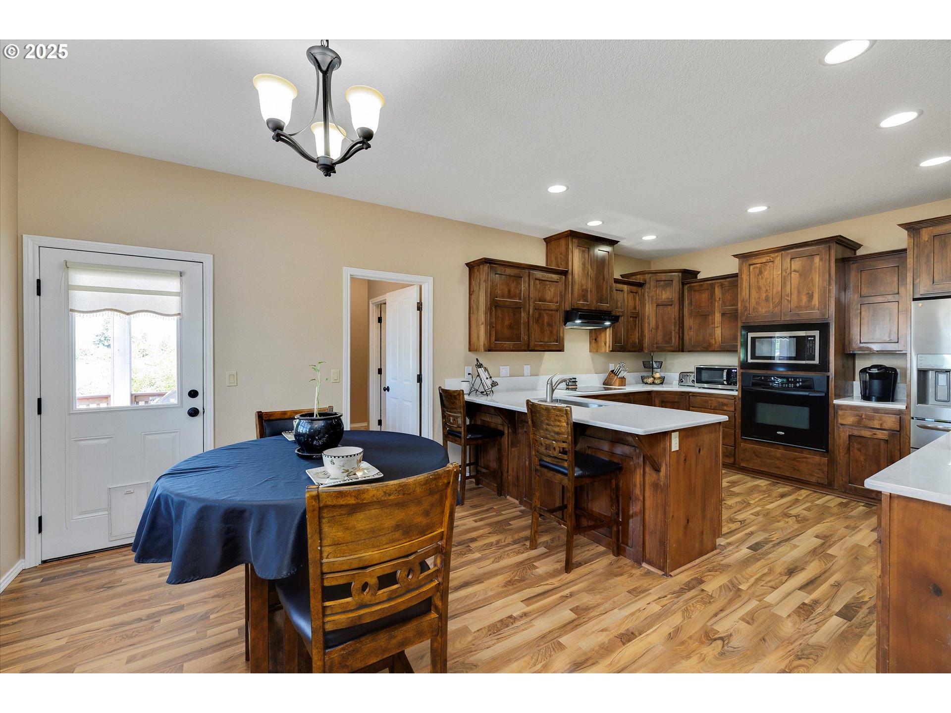 125 Telford Road Oregon City, OR 97045 - Photo 15 of 42 a open kitchen with stainless steel appliances kitchen island granite countertop a table chairs and a refrigerator