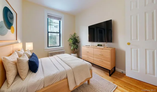 a bedroom with a bed tv and window