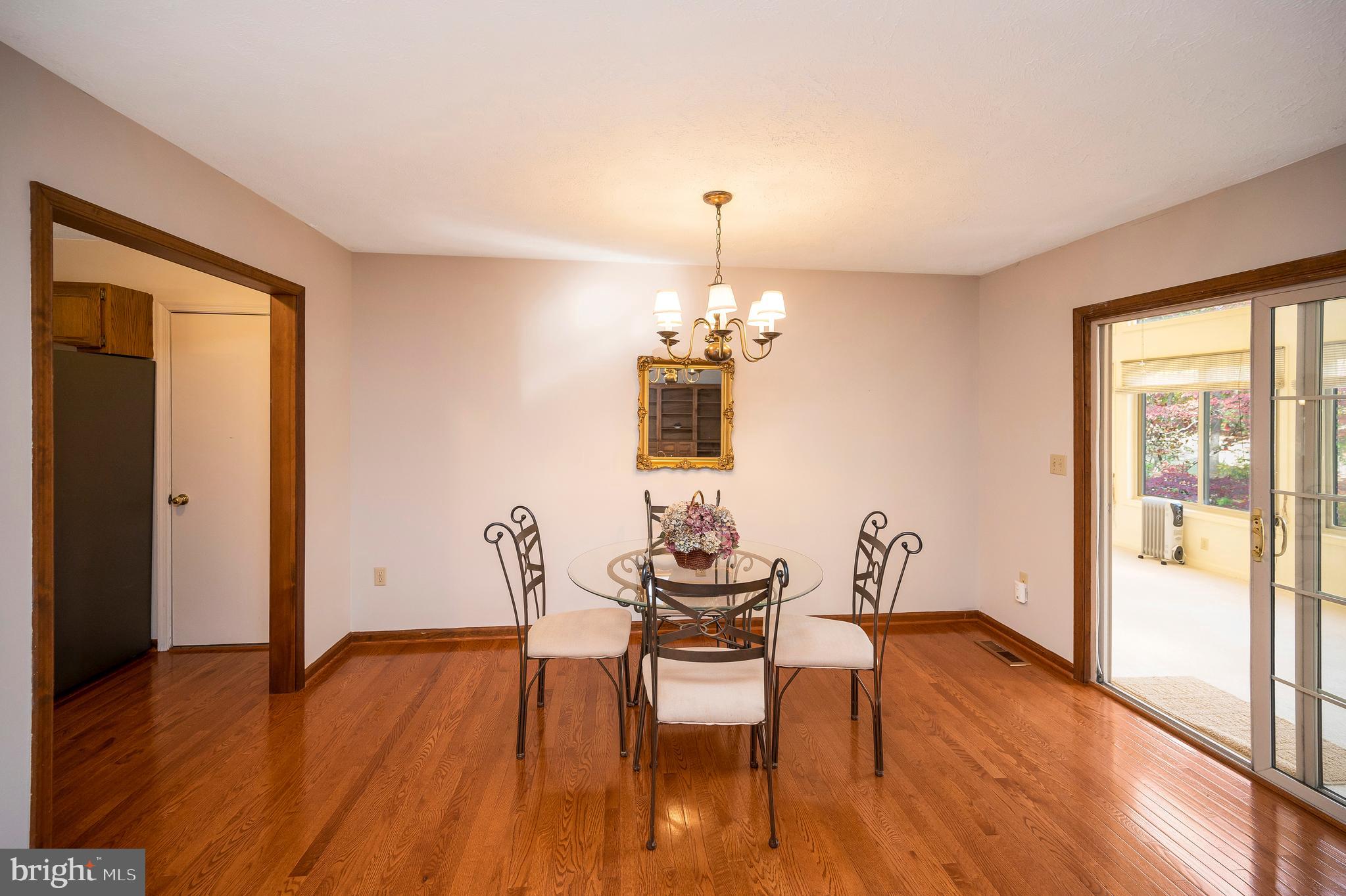 104 Appleview Court Locust Grove, VA 22508 - Photo 9 of 65 a dining room with wooden floor a chandelier a glass table and chairs