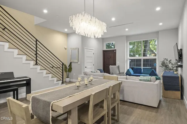 a view of a dining room with furniture a chandelier and wooden floor