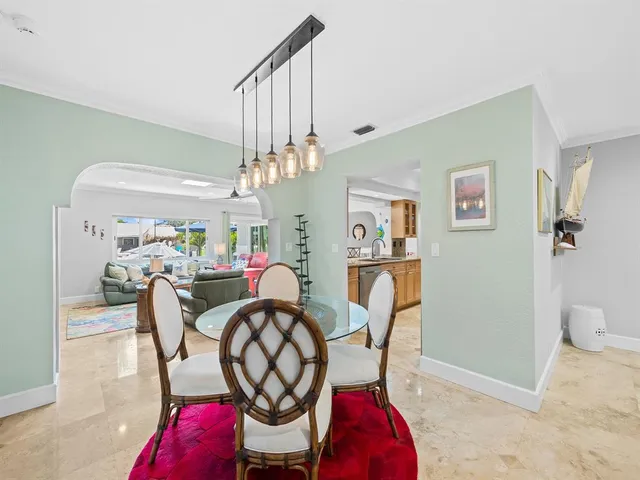 a living room filled with furniture and a dining table with wooden floor