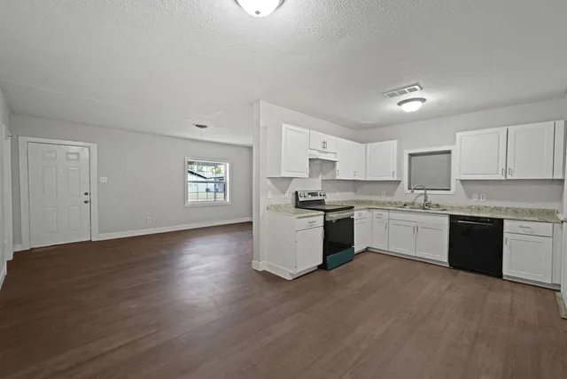 a kitchen with granite countertop white cabinets and white appliances