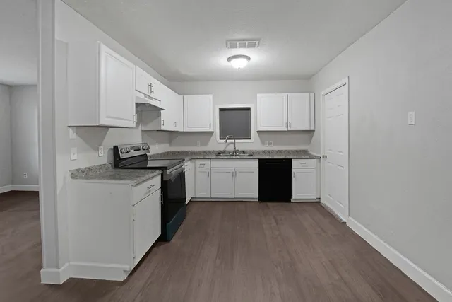 a kitchen with a white cabinets sink and stainless steel appliances