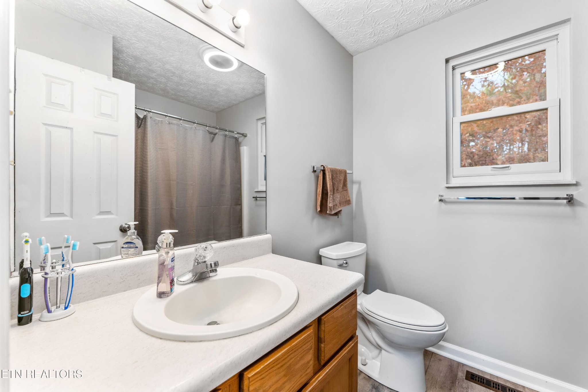 1935 Poplar Hill Road Knoxville, TN 37922 - Photo 17 of 25 a bathroom with a sink a toilet and mirror