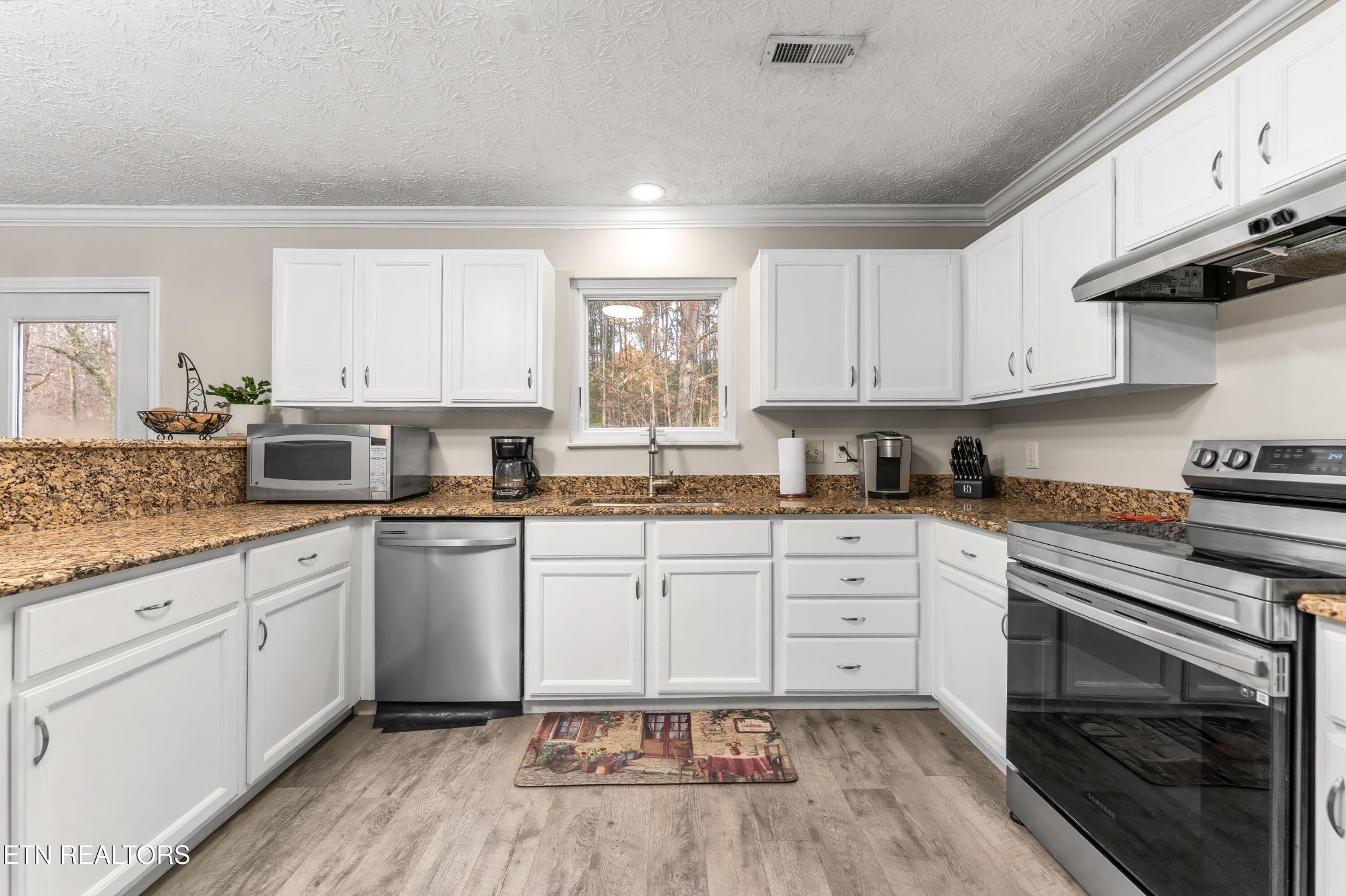 1935 Poplar Hill Road Knoxville, TN 37922 - Photo 5 of 25 a kitchen with granite countertop white cabinets stainless steel appliances a sink and a stove