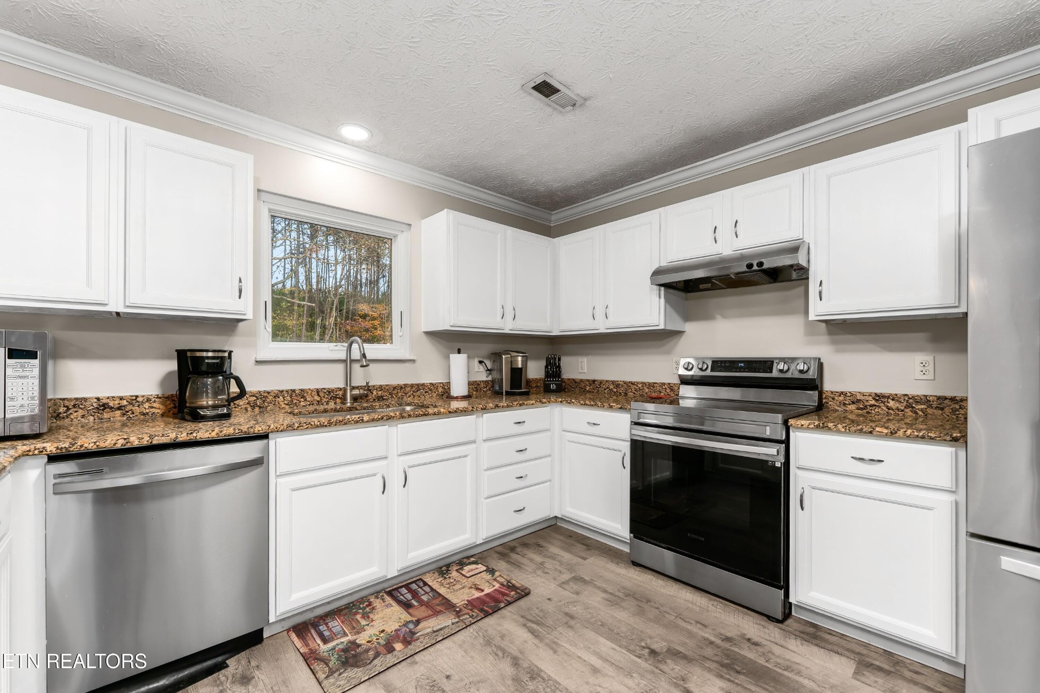 1935 Poplar Hill Road Knoxville, TN 37922 - Photo 6 of 25 a kitchen with granite countertop white cabinets and white appliances