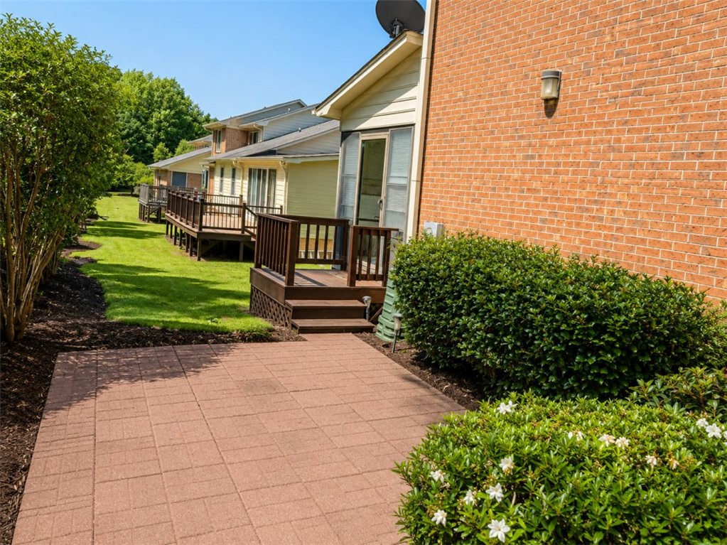 2018 Cardinal Park Drive Anderson, SC 29621 - Photo 7 of 11 A neatly paved patio extends to multiple decks, offering serene views of green lawn and mature landscaping.