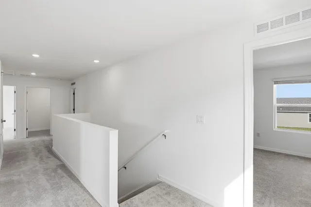 a view of hallway with furniture and a window