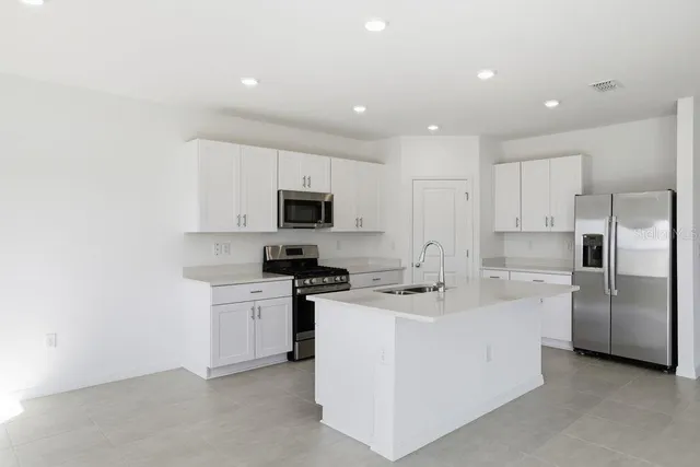 a kitchen with stainless steel appliances a sink stove and refrigerator