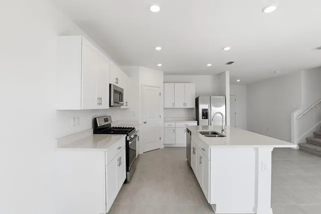 a kitchen with stainless steel appliances a sink stove and refrigerator