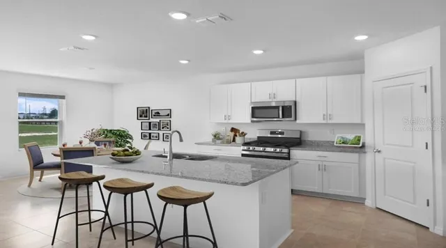 a kitchen with sink a stove and cabinets