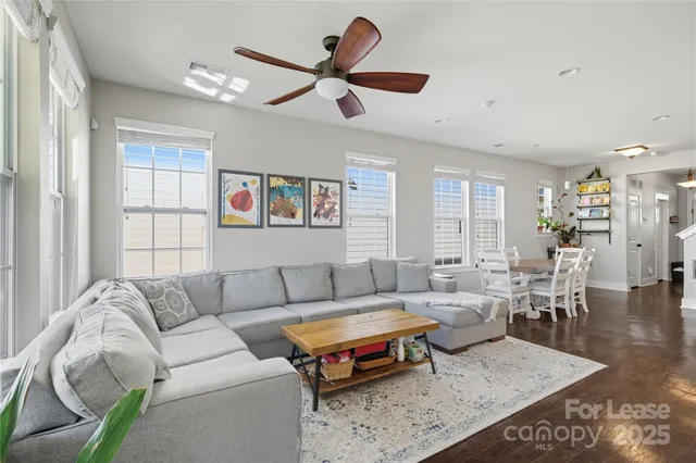 a living room with furniture ceiling fan and a window