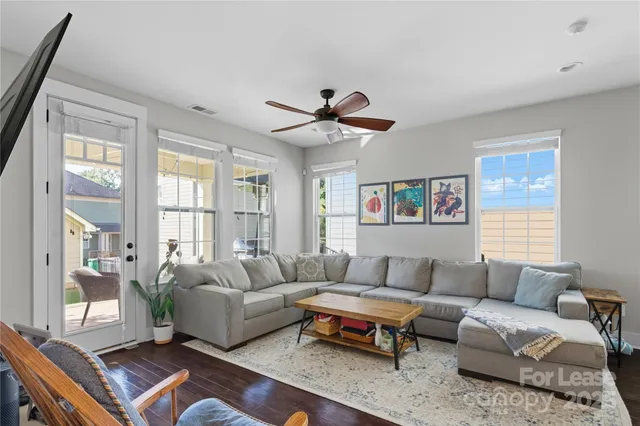 a living room with furniture a ceiling fan and a window