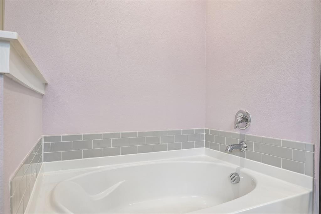 1805 Huntsman Way Forney, TX 75126 - Photo 27 of 34 Corner soaking tub with subway tile surround, chrome fixtures, and a white finish