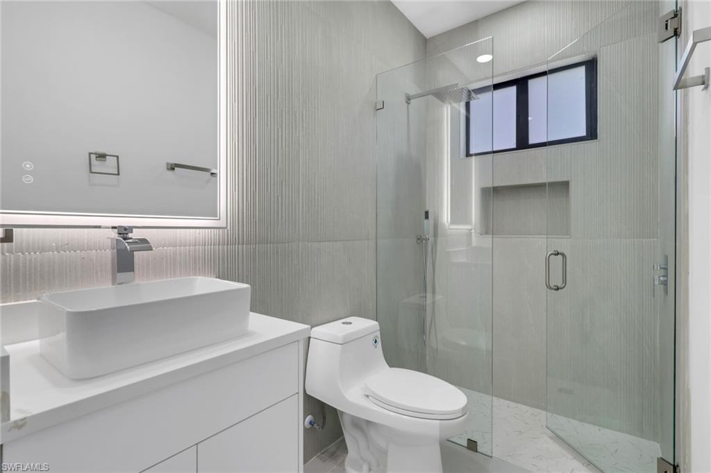 730 29th Street Southwest Naples, FL 34117 - Photo 30 of 50 Bathroom with a stall shower, a soaking tub, healthy amount of natural light, and marble tiled flooring