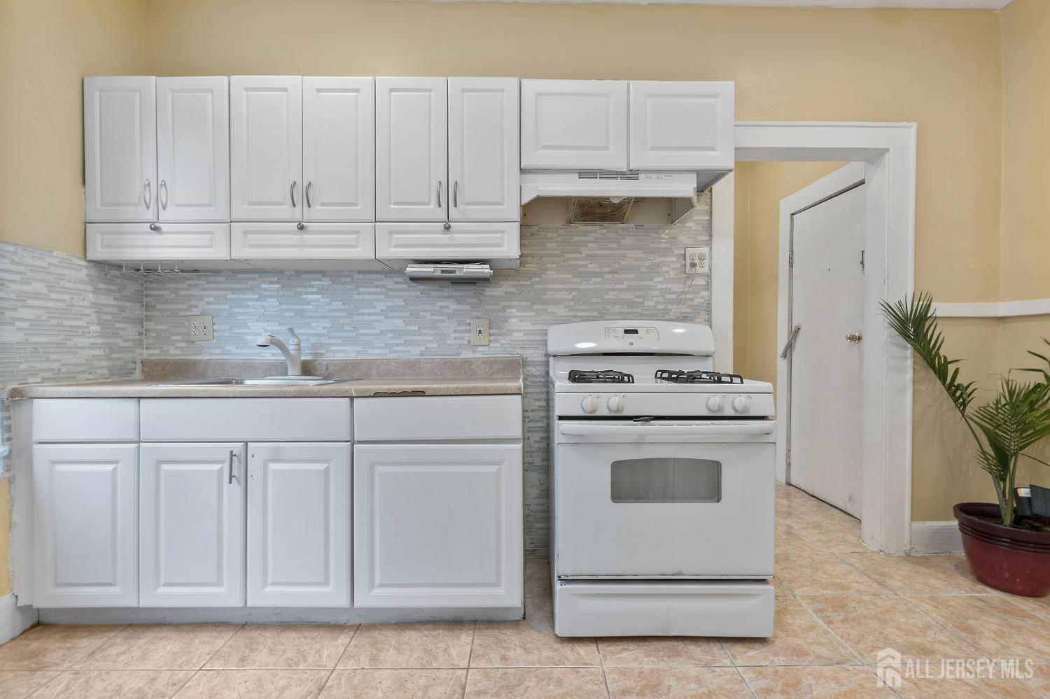213 Maple Avenue, Unit 1 Irvington, NJ 07111 - Photo 17 of 17 a kitchen with white cabinets and white appliances