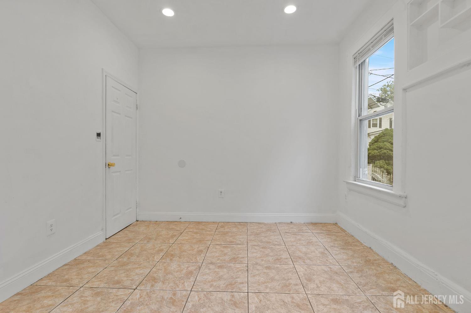 213 Maple Avenue, Unit 1 Irvington, NJ 07111 - Photo 9 of 17 an empty room with windows