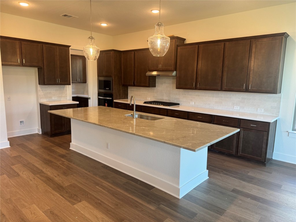1828 Camay Street Leander, TX 78641 - Photo 2 of 15 a large kitchen with wooden floor and stainless steel appliances