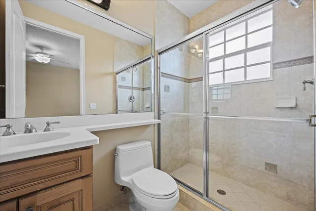 a bathroom with a granite countertop sink a toilet and shower