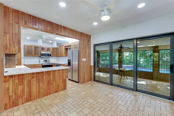 a large kitchen with stainless steel appliances a large counter top a refrigerator and a sink
