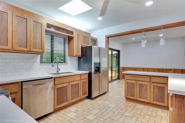 a kitchen with stainless steel appliances granite countertop a refrigerator and a sink